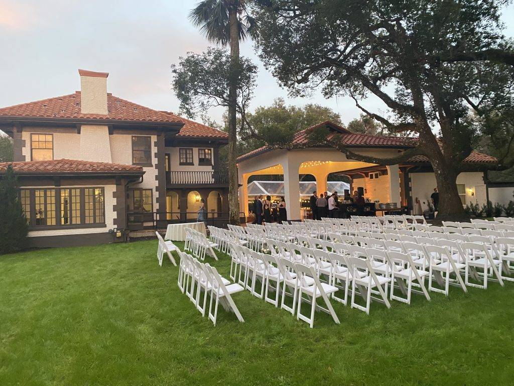 Ceremony chairs with outdoor pavilion and clear tent in the background